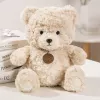 LEAN TOYS Pliušinis talismanas, minkštas žaislas, meškiukas su medalionu, smėlio spalvos, 25 cm